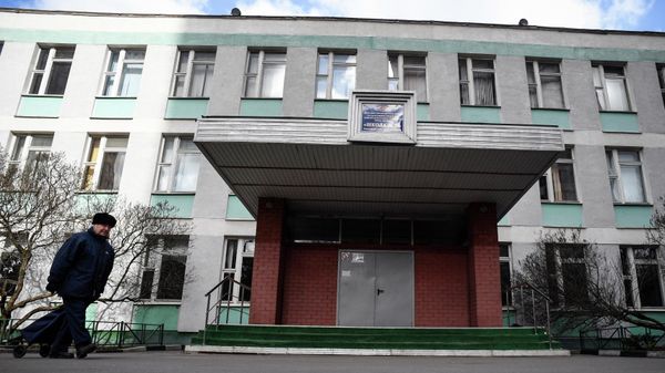 A man walks past a closed school in Moscow on March 23, 2020. - Sputnik International