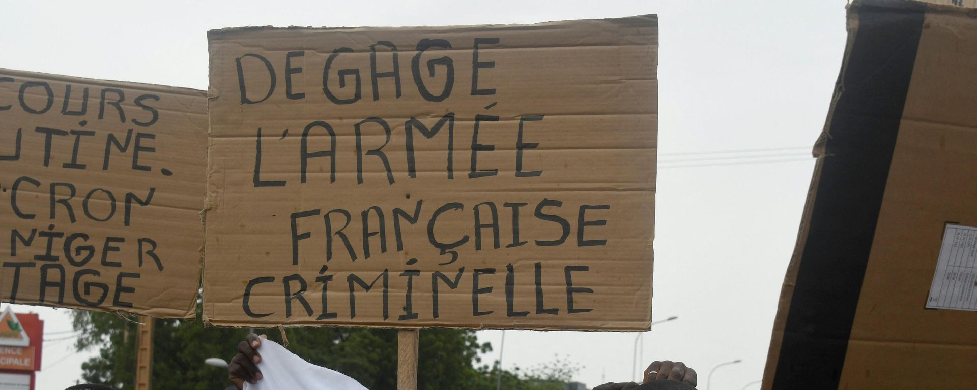 A man holds a placard reading Clear off criminal French army as people demonstrate against French military presence in Niger on September 18, 2022 in Niamey. A man holds a placard reading Clear off criminal French army as people demonstrate against French military presence in Niger on September 18, 2022 in Niamey. - Sputnik International, 1920, 11.11.2022