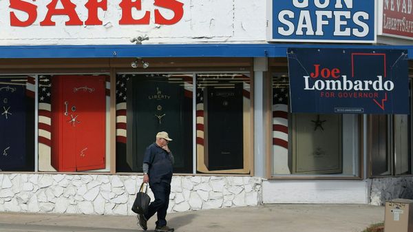 A pedestrian walks past a store displaying support for Nevada Republican candidate for governor Joe Lombardo - Sputnik International