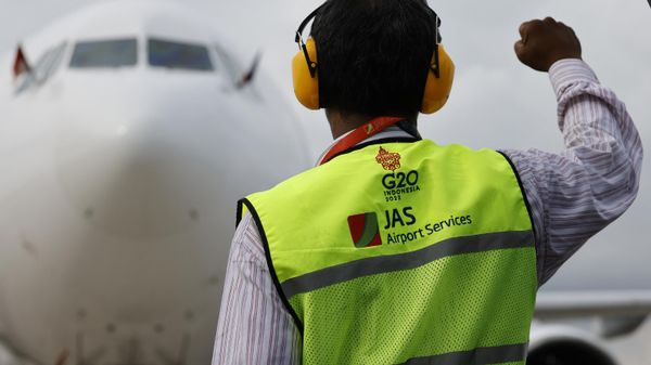 An airport's employee gestures as the aircraft of French President lands at Ngurah Rai International airport in Denpasar on the Indonesian resort island of Bali before G20 Summit on November 14, 2022 - Sputnik International