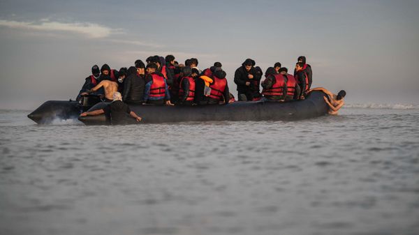 A smuggler fixes the boat's engine on the beach of Gravelines, near Dunkirk, northern France on October 12, 2022, in an attempt to cross the English Channel - Sputnik International