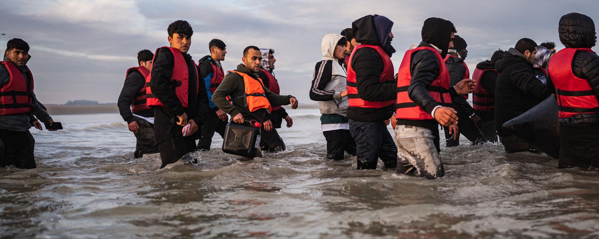 Migrants board a smuggler's boat on the beach of Gravelines, near Dunkirk, northern France on October 12, 2022, in an attempt to cross the English Channel - Sputnik International, 1920, 15.11.2022