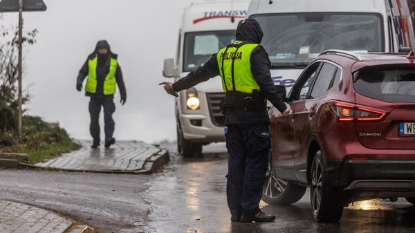 A policeman talks to a driver on the street near the site where a missile strike killed two men in the eastern Poland village of Przewodow - Sputnik International