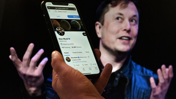 (FILES) In this file photo illustration taken on April 14, 2022 a phone screen displays the Twitter account of Elon Musk with a photo of him shown in the background, in Washington, DC. (FILES) In this file photo illustration taken on April 14, 2022 a phone screen displays the Twitter account of Elon Musk with a photo of him shown in the background, in Washington, DC. - Sputnik International