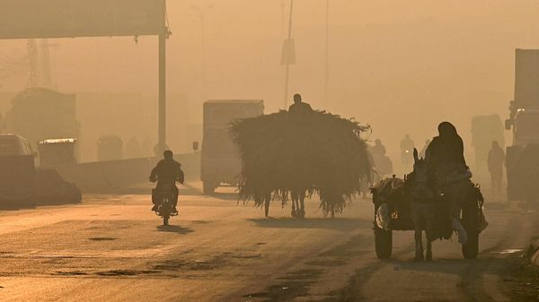 Commuters make their way along a street amid heavy smog in Lahore on November 18, 2022. - Sputnik International