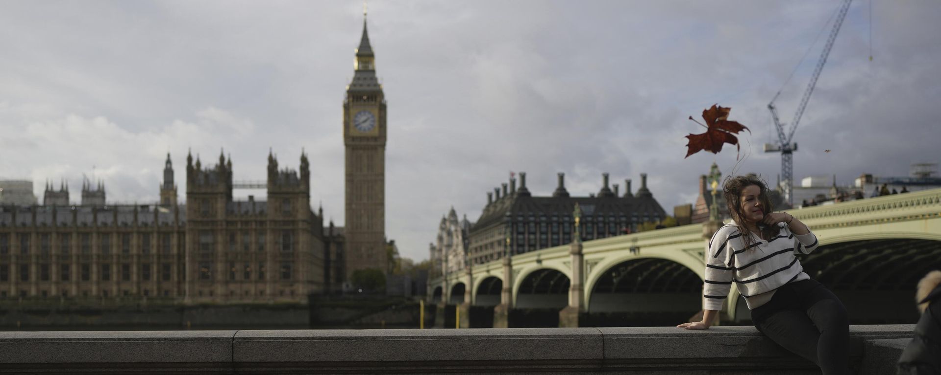 A woman poses for a photograph in front of the Houses of Parliament A woman poses for a photograph in front of the Houses of Parliament - Sputnik International, 1920, 24.11.2022