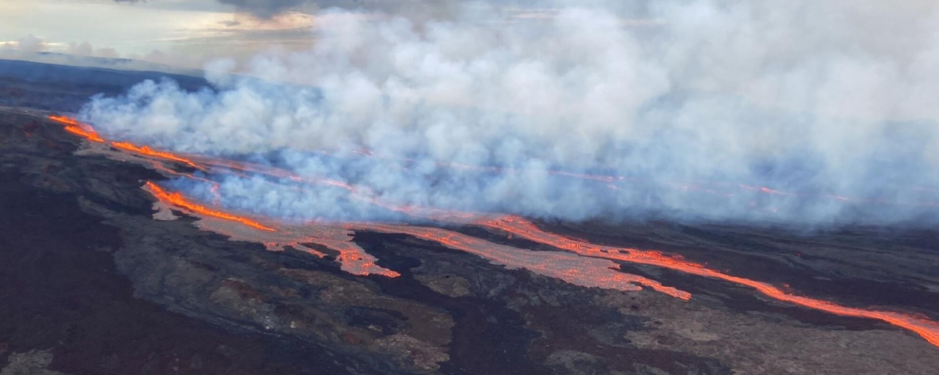 In this aerial photo released by the U.S. Geological Survey, the Mauna Loa volcano is seen erupting from vents on the Northeast Rift Zone on the Big Island of Hawaii, Monday, Nov. 28, 2022. Hawaii's Mauna Loa, the world's largest active volcano, began spewing ash and debris from its summit, prompting civil defense officials to warn residents on Monday to prepare in case the eruption causes lava to flow toward communities. In this aerial photo released by the U.S. Geological Survey, the Mauna Loa volcano is seen erupting from vents on the Northeast Rift Zone on the Big Island of Hawaii, Monday, Nov. 28, 2022. Hawaii's Mauna Loa, the world's largest active volcano, began spewing ash and debris from its summit, prompting civil defense officials to warn residents on Monday to prepare in case the eruption causes lava to flow toward communities. - Sputnik International, 1920, 02.12.2022