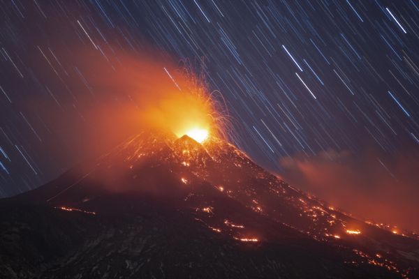 An image of Star Trails and Lava Plume on Mount Etna by Italian photographer Dario Giannobile, in the top 101 of The 9th International Landscape Photographer of the Year. On the afternoon of February 16, Etna began an extremely intense eruptive phase. For days its summit craters, including especially the new southeast crater, showed significant eruptive activity that manifested itself mainly in the release of dust and sporadic explosions of a Strombolian character accompanied by lava fountains. At about 5 p.m. a very important column of ash rose from the new southeast crater accompanied by an equally important increase in volcanic tremor (see attached file). Together with the cloud, which in the meantime had extended so far as to reach the province of Syracuse, the crater poured out an extensive lava flow that, in a short time, reached the Bove (ox) valley flowing on its slopes. The lava fountains were so high and intense that they were visible even from a distance and in sunlight. Seeing what was happening, I headed toward the volcano in hopes of photographing the night sky and lava flow. The first shots were taken at the Piano Vetore location and show the activity going on at the new southeast crater taken at high magnification. Behind the blanket of dust it is possible to see the stars that traced a trail of stars during the show. Next I moved to Mount Zoccolaro reaching the edge of the Bove Valley. From there I photographed the lava flow that, as it flowed, had drawn a 5-pointed star almost reflecting the beauty of the starry sky on earth. During the shots, a brilliant meteor plowed through the framed field to finish its course just above the erupting crater (you can see the color change from green to red). The landscapes are characterized by streaks of black lava (the sciara) mixed with black dust and snow. The evening ended with two more shots. The first shows the beautiful. - Sputnik International