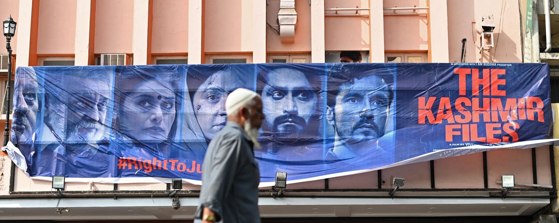 A man walks past a banner of Bollywood movie 'The Kashmir Files' installed outside a cinema hall in the old quarters of Delhi on March 21, 2022. A man walks past a banner of Bollywood movie 'The Kashmir Files' installed outside a cinema hall in the old quarters of Delhi on March 21, 2022. - Sputnik International, 1920, 29.11.2022
