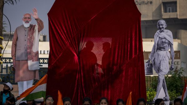 Cut out photos of Indian Prime Minister Narendra Modi, left and Mahatma Gandhi, right, are erected next to veiled G20 logo before its unveiling ceremony in New Delhi, India, Thursday, Dec. 1, 2022. - Sputnik International