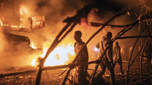 People walk by U.N. vehicles which were set on fire, in Goma, Democratic Republic of Congo, Tuesday Nov. 1, 2022. Angry crowds in eastern Congo have set fire to U.N. vehicles as frustrations mount over the advance of M23 rebels. The violence late Tuesday came amid false rumors that the U.N. had transported rebels. - Sputnik International
