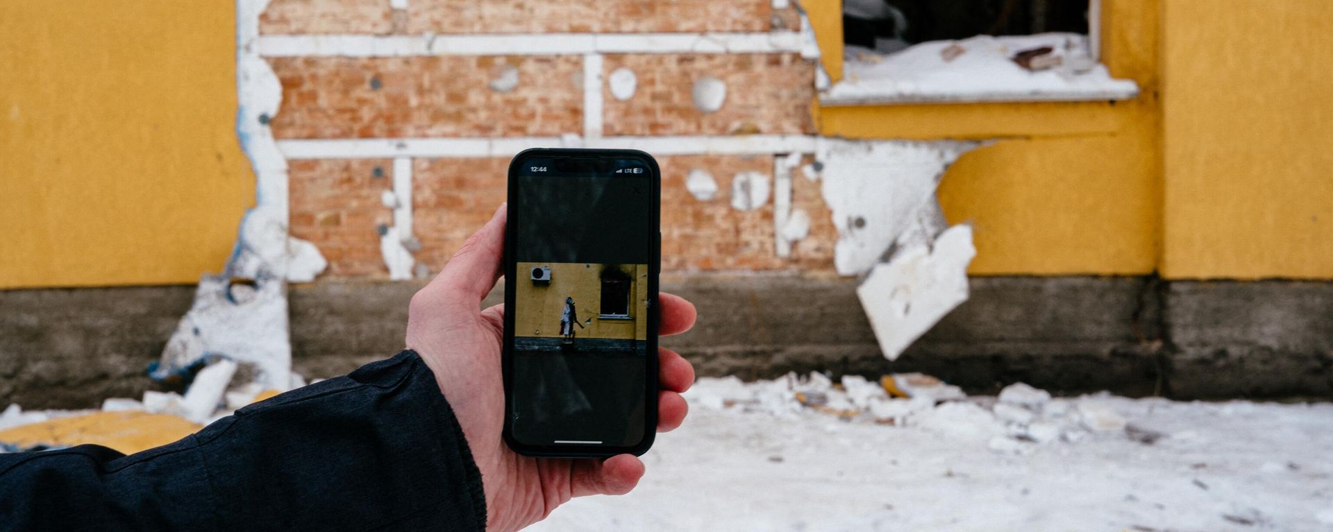This photograph taken on December 3, 2022 shows a mobile phone with Banksy's work on the screen in front of a cut off of the wall of a damaged building from where a group of people tried to steal this work of the famous British artist in the town of Gostomel, near Kiev. This photograph taken on December 3, 2022 shows a mobile phone with Banksy's work on the screen in front of a cut off of the wall of a damaged building from where a group of people tried to steal this work of the famous British artist in the town of Gostomel, near Kiev. - Sputnik International, 1920, 03.12.2022