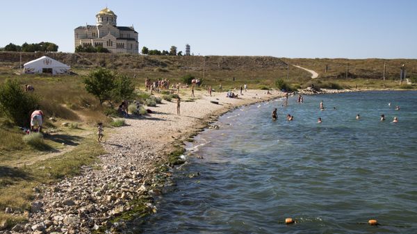 In this photo taken on Friday, Aug. 7, 2015, people gather at the beach area of the Black Sea, near to the area that was the ancient Greek colony of Chersonesus, and with the St. Vladimir's Cathedral in the background, just outside Sevastopol, the main port city in Crimea, the Black Sea Peninsula . In this photo taken on Friday, Aug. 7, 2015, people gather at the beach area of the Black Sea, near to the area that was the ancient Greek colony of Chersonesus, and with the St. Vladimir's Cathedral in the background, just outside Sevastopol, the main port city in Crimea, the Black Sea Peninsula . - Sputnik International
