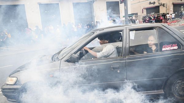 People take cover from tear gas thrown by the police during clashes on a demonstration held by supporters of former President Pedro Castillo demanding his release and the closure of the Peruvian Congress in Lima, on December 11, 2022 - Sputnik International