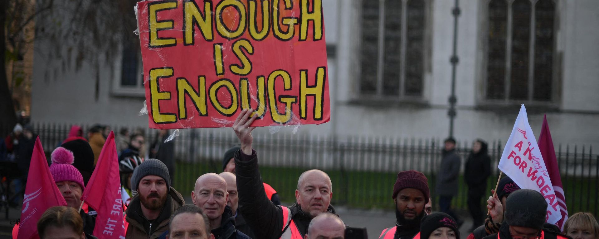 A demonstrator holds a sign reading 'Enough is Enough' as they take part in a rally organised by the Communication Workers Union (CWU), in support of Royal Mail postal workers who are on strike, in Parliament Square in central London on December 9, 2022. - Sputnik International, 1920, 26.01.2023