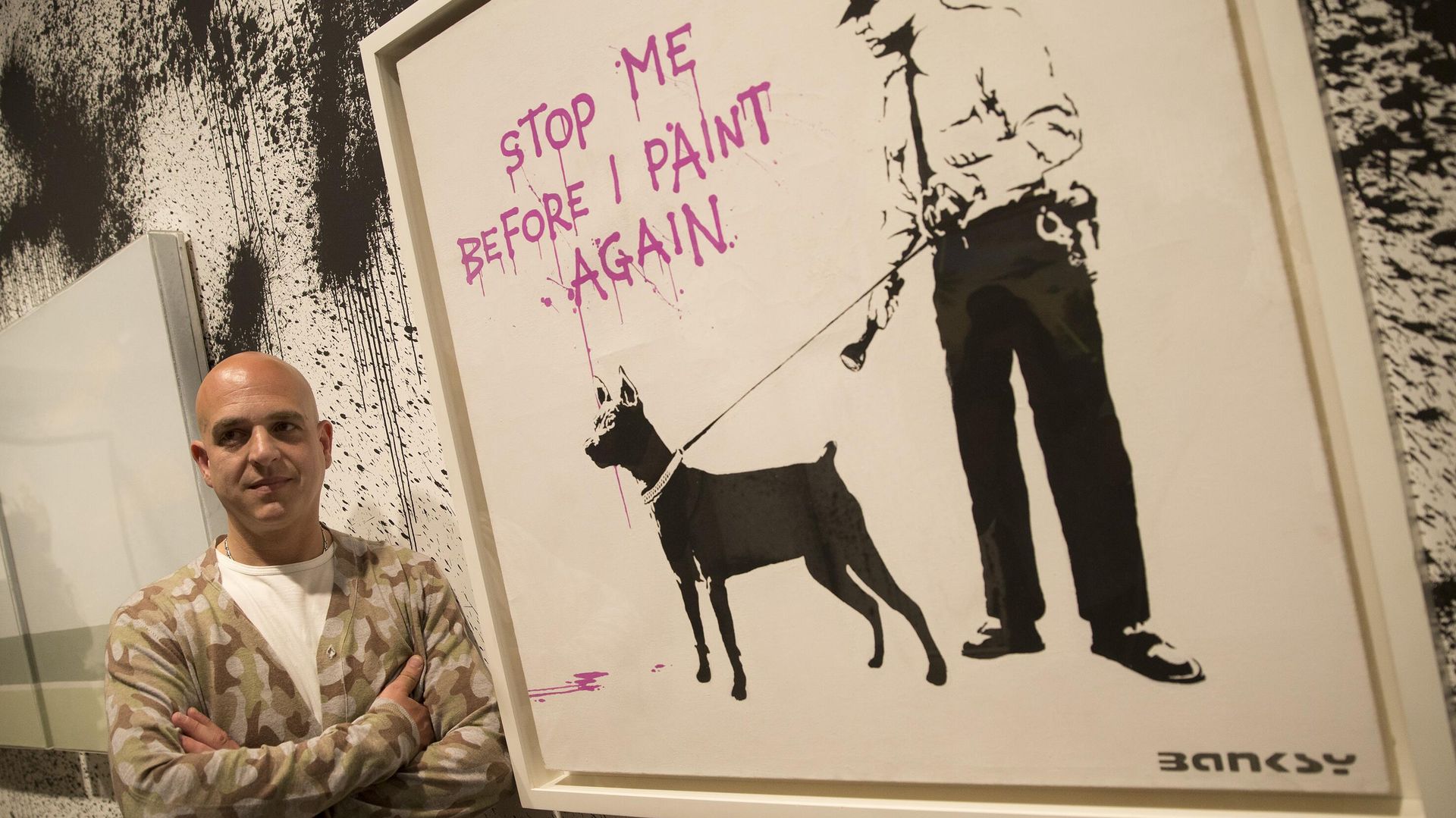 Curator Steve Lazarides poses for a portrait next to at art work by British artist Banksy. - Sputnik International, 1920, 12.12.2022