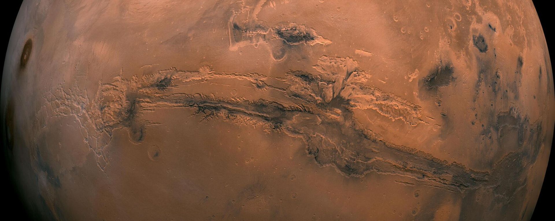 This mosaic of Mars is a compilation of images captured by the Viking Orbiter 1. The center of the scene shows the entire Valles Marineris canyon system, more than 2,000 miles (3,000 kilometers) long, 370 miles (600 kilometers) wide and 5 miles (8 kilometers) deep, extending from Noctis Labyrinthus, the arcuate system of graben to the west, to the chaotic terrain to the east. This mosaic of Mars is a compilation of images captured by the Viking Orbiter 1. The center of the scene shows the entire Valles Marineris canyon system, more than 2,000 miles (3,000 kilometers) long, 370 miles (600 kilometers) wide and 5 miles (8 kilometers) deep, extending from Noctis Labyrinthus, the arcuate system of graben to the west, to the chaotic terrain to the east. - Sputnik International, 1920, 10.02.2023