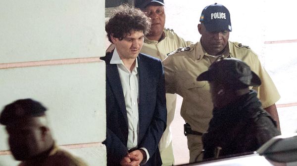FTX founder Sam Bankman-Fried (2nd L) is led away handcuffed by officers of the Royal Bahamas Police Force in Nassau, Bahamas on December 13, 2022. - Sputnik International