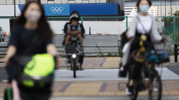 Women carry their children on their bicycles as they ride through an intersection near a sporting arena planned to be used during the Tokyo 2020 Olympic and Paralympic Games in Tokyo on June 24, 2021 - Sputnik International