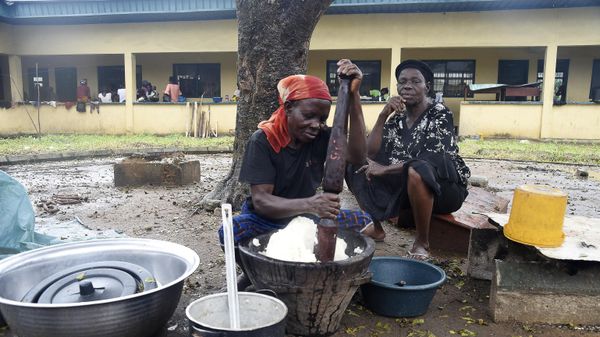 A woman pounds ingredients in a mortar as she prepares food in an internally displaced people's (IDP) camp, where flood evacuees are accommodated, at Community Primary School in Ihuike, Niger delta region of Ahoada, Rivers State, southern Nigeria, on October 21, 2022 - Sputnik International