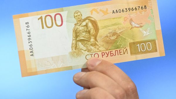 Russia's Central Bank official shows an updated version of 100-rubles banknote .  - Sputnik International