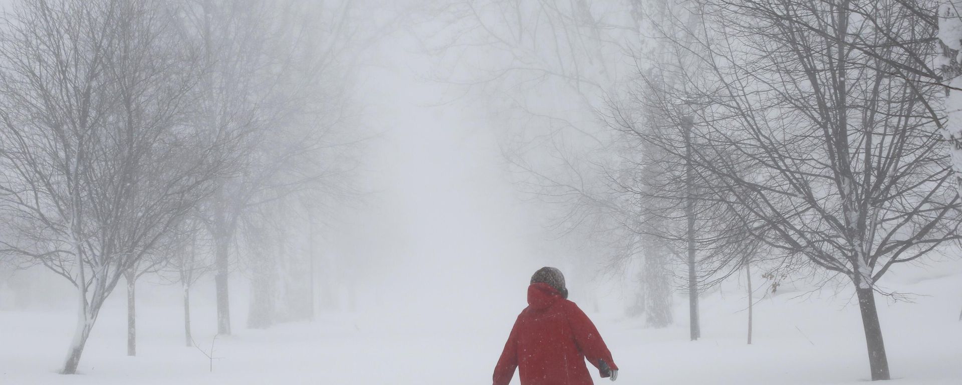 A person walks on the street as a winter storm rolls through Western New York Saturday, Dec. 24, 2022, in Amherst N.Y. A person walks on the street as a winter storm rolls through Western New York Saturday, Dec. 24, 2022, in Amherst N.Y. - Sputnik International, 1920, 25.12.2022