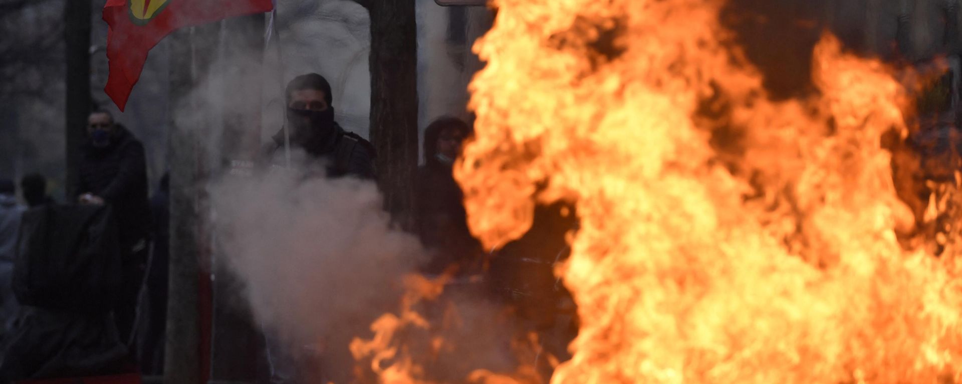 A protester holds a Kurdish workers party (PKK) flag behind a fire during clashes following a demonstration of supporters and members of the Kurdish community, a day after a gunman opened fire at a Kurdish cultural centre killing three people, at The Place de la Republique in Paris on December 24, 2022 A protester holds a Kurdish workers party (PKK) flag behind a fire during clashes following a demonstration of supporters and members of the Kurdish community, a day after a gunman opened fire at a Kurdish cultural centre killing three people, at The Place de la Republique in Paris on December 24, 2022 - Sputnik International, 1920, 25.12.2022