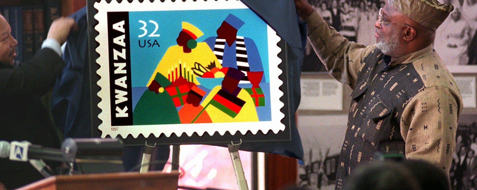 Harold Anderson, left, joins Jose Ferrer, right, chairman of the Kwanzaa Holiday Foundation, to unveil the new Kwanzaa postage stamp at the Shomburg Center for Research in Black Culture in Harlem, New York, Wednesday, Nov. 12, 1997. Ferrer, who is from the Bronx borough of New York, led efforts to create the stamp and says this will make America aknowledge the importance of this great celebration and the affirmation of our culture. The commemorative Holiday Celebration stamp series pays tribute to the African-American family and community. Harold Anderson, left, joins Jose Ferrer, right, chairman of the Kwanzaa Holiday Foundation, to unveil the new Kwanzaa postage stamp at the Shomburg Center for Research in Black Culture in Harlem, New York, Wednesday, Nov. 12, 1997. Ferrer, who is from the Bronx borough of New York, led efforts to create the stamp and says this will make America aknowledge the importance of this great celebration and the affirmation of our culture. The commemorative Holiday Celebration stamp series pays tribute to the African-American family and community. - Sputnik International, 1920, 26.12.2022