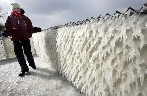 Lauren Basil of Clarence, New York admires the wind-blown ice on a fence in her friend's front yard along the shore of Lake Erie in Hamburg, New York on Friday 17 February 2006.  - Sputnik International