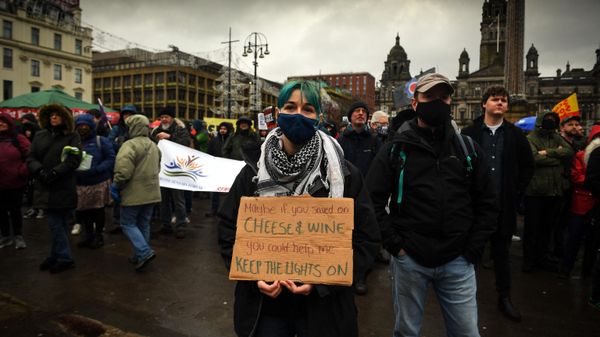 Demonstrators hold up placards as they take part in a march organised by The People's Assembly to demand action to tackle the cost of living crisis in Glasgow, Scotland on February 12, 2022. - Sputnik International