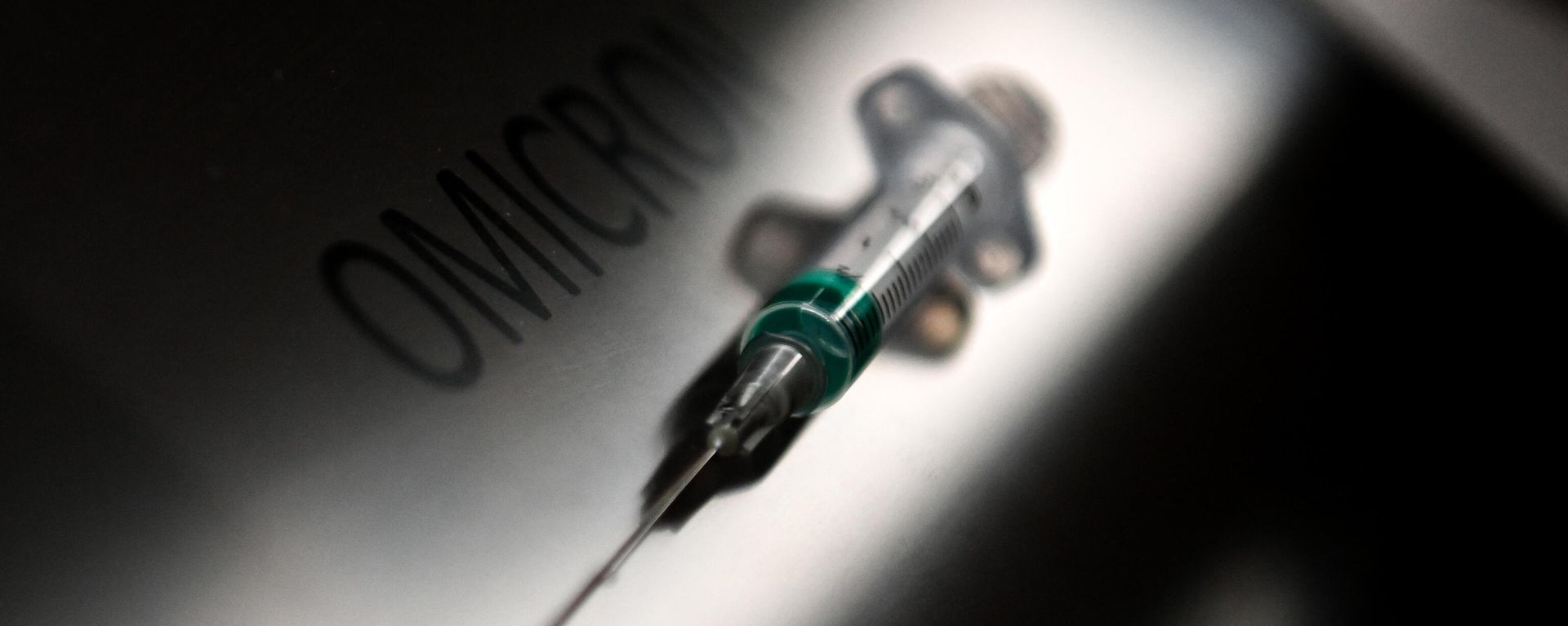 An illustration picture taken on January 19, 2022, shows a syringe next to the word Omicron.  - Sputnik International, 1920, 05.01.2023