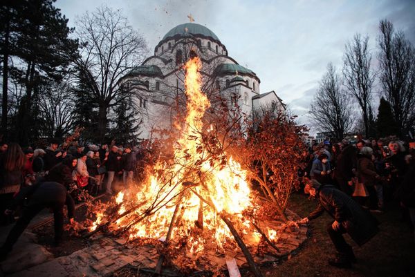 People attend the annual ceremony of lighting a bonfire of dried oak branches, the Yule log symbol for the Orthodox Christmas Eve, according to the Julian calendar, at the Church of Saint Sava in Belgrade on January 6. (Photo by OLIVER BUNIC / AFP) - Sputnik International