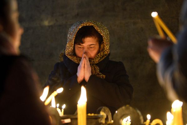 An Orthodox believer prays during a religious service on the eve of Orthodox Christmas  at a cathedral in the capital Yerevan, Armenia, on January 6. (Photo by KAREN MINASYAN / AFP) - Sputnik International