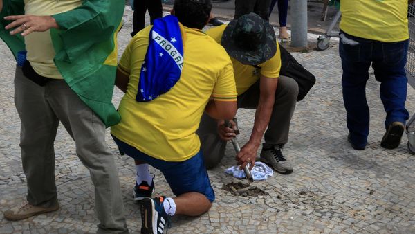 Supporters of Brazilian former President Jair Bolsonaro damage the sidewalk to obtain stones during clashes with riot police outside Planalto Presidential Palace - Sputnik International