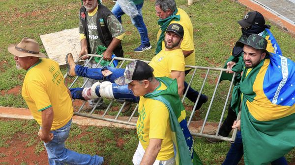 A supporter of Brazilian former President Jair Bolsonaro is evacuated by fellow supporters after being wounded during clashes with riot police  - Sputnik International