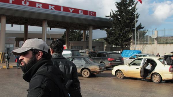 People and cars wait at the Bab al-Hawa customs gate at theSyria-Turkey border in Idlib province, north Syria - Sputnik International