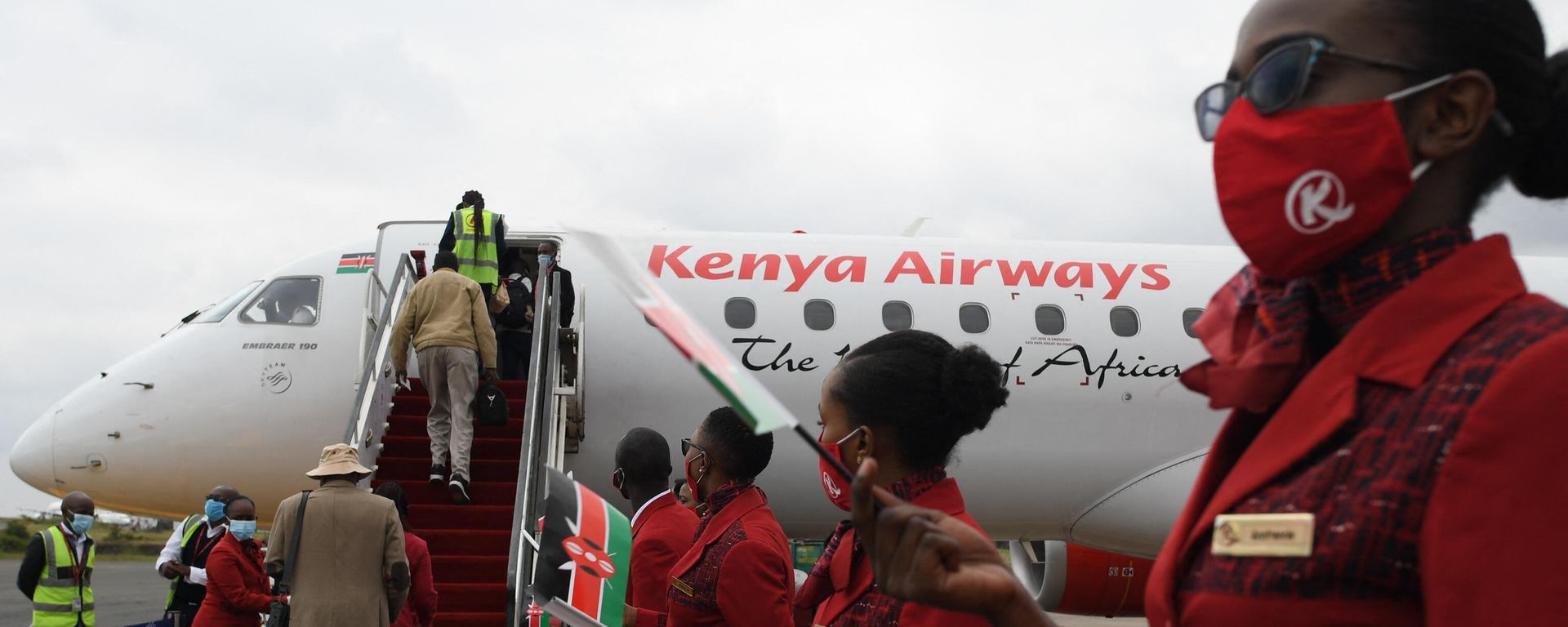 Kenya Airways cabin crew members (R), waive flags as they usher passengers at the Jomo Kenyatta International Airport (JKIA), after the official launch on resumption of local flights in Nairobi, on July 15, 2020. Kenya Airways cabin crew members (R), waive flags as they usher passengers at the Jomo Kenyatta International Airport (JKIA), after the official launch on resumption of local flights in Nairobi, on July 15, 2020. - Sputnik International, 1920, 10.01.2023