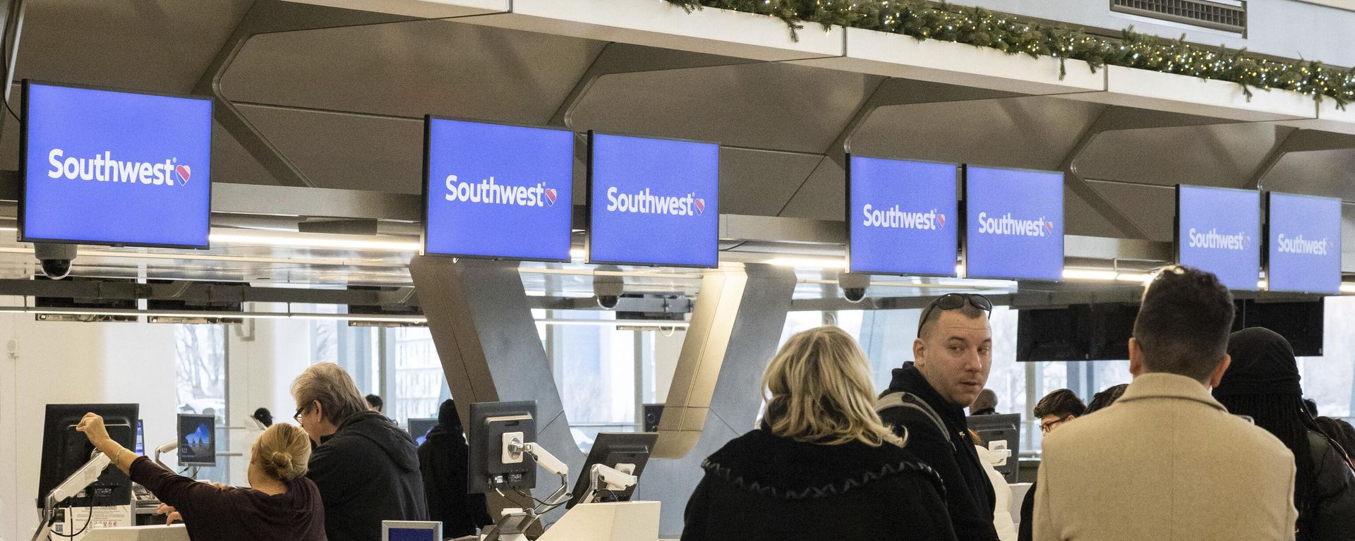 Passengers wait in line to check in for their flights at Southwest Airlines service desk at LaGuardia Airport, Tuesday, Dec. 27, 2022, in New York.  - Sputnik International, 1920, 23.06.2026