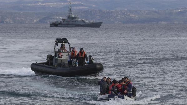 A dinghy with Afghan refugees approaches the Greek island of Lesbos on February 28, 2020 next to UK Border Force patrol boat HMC Valiant, patroling in Agean sea under European Union border force Frontex. - Sputnik International