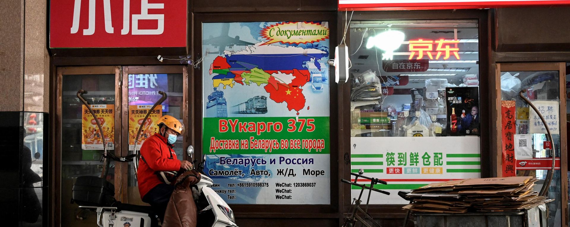 A delivery man stands in front of an billboard advertising international logistics transportation to Russia, outside a convenience store in Ritan International Trade Center in Beijing on March 22, 2022. A delivery man stands in front of an billboard advertising international logistics transportation to Russia, outside a convenience store in Ritan International Trade Center in Beijing on March 22, 2022. - Sputnik International, 1920, 13.01.2023