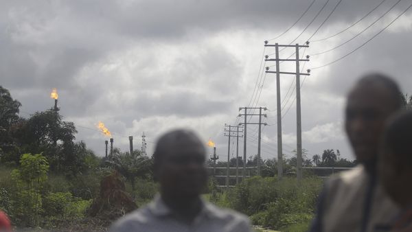 Local people stand and talk with gas flares belonging to the Agip Oil company in the background in Idu, Niger Delta area of Nigeria, Friday, Oct. 8, 2021 - Sputnik International