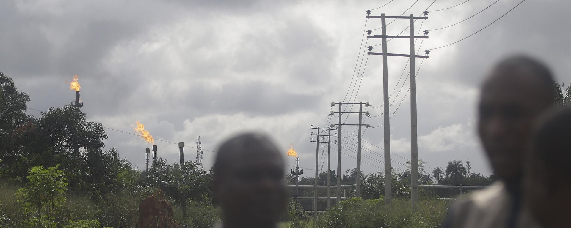 Local people stand and talk with gas flares belonging to the Agip Oil company in the background in Idu, Niger Delta area of Nigeria, Friday, Oct. 8, 2021 Local people stand and talk with gas flares belonging to the Agip Oil company in the background in Idu, Niger Delta area of Nigeria, Friday, Oct. 8, 2021 - Sputnik International, 1920, 14.01.2023