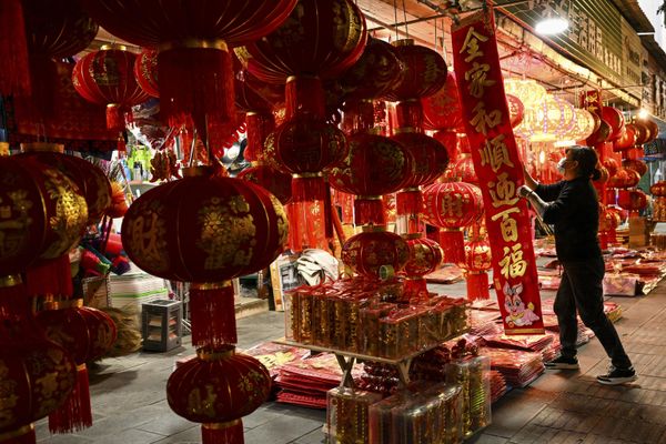 A vendor arranges Chinese lanterns and other decorations for sale for the upcoming Chinese Lunar New Year celebrations along a street in the county-level city of Ruili in Dehong prefecture, in China's west Yunnan Province. - Sputnik International
