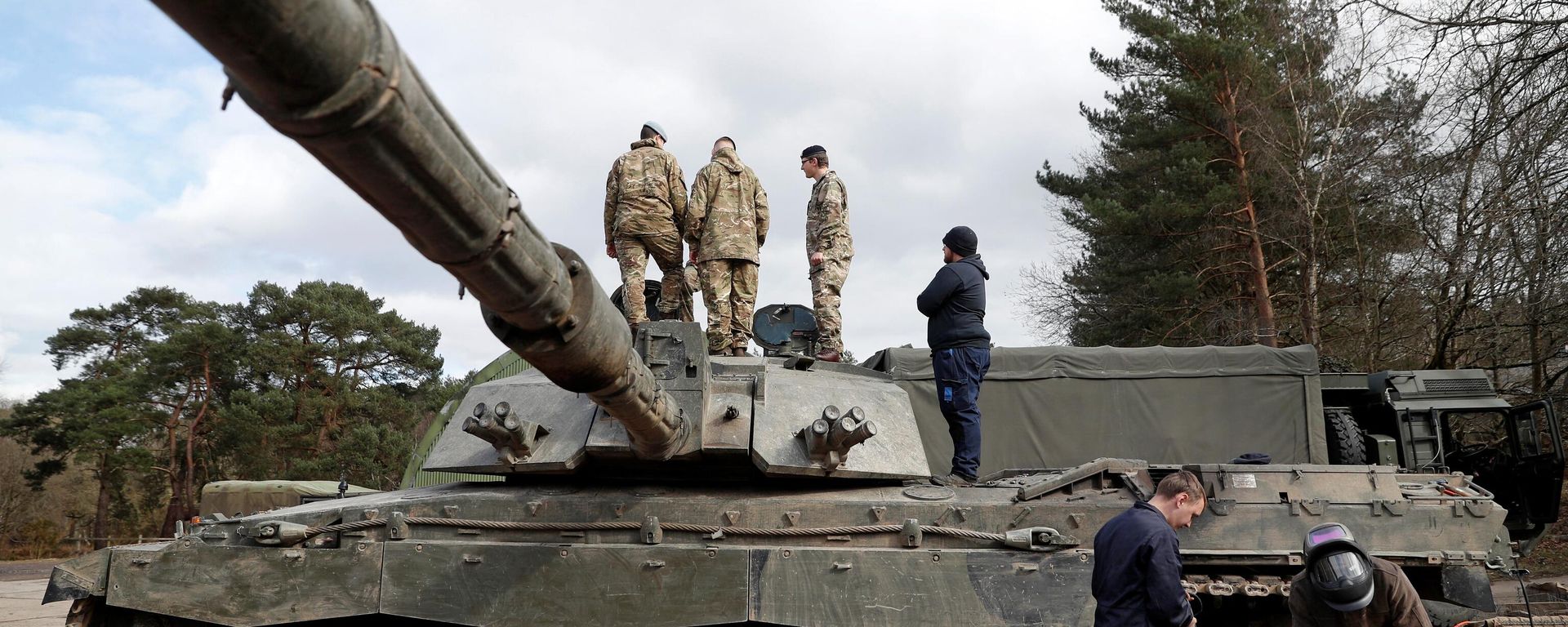 Soldiers work on a Challenger 2 main battle tank during during the Royal Electrical & Mechanical Engineers’ training exercise called Iron Challenge at the Longmoor training area, near Bordon, Hampshire, on March 14, 2022 Soldiers work on a Challenger 2 main battle tank during during the Royal Electrical & Mechanical Engineers’ training exercise called Iron Challenge at the Longmoor training area, near Bordon, Hampshire, on March 14, 2022 - Sputnik International, 1920, 18.01.2023