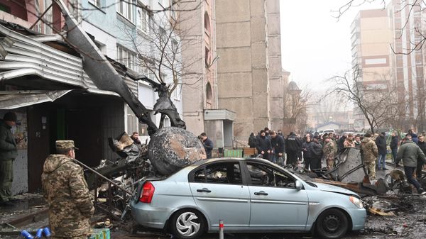 Military and onlookers stand at the site where a helicopter crashed near a kindergarten outside the capital Kiev, killing sixteen people, including two children and Ukrainian interior minister, on January 18, 2023. - Sputnik International