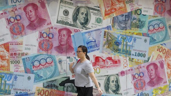 A woman walks by a money exchange shop decorated with banknotes of Chinese yuan and US dollars at Central, a business district in Hong Kong, Tuesday, Aug. 6, 2019. - Sputnik International