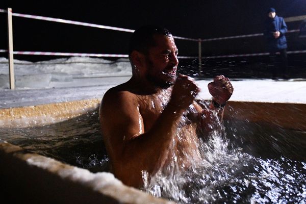 A man sits in a fountain during the celebration of Epiphany on Lake Shartash in Yekaterinburg. - Sputnik International