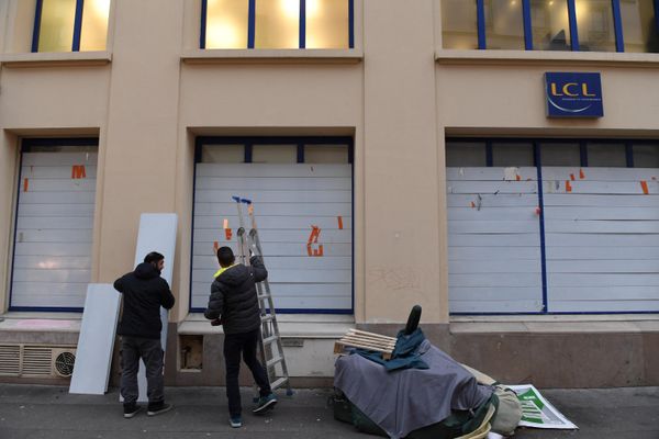 Workers board up the windows of a bank branch located on the route of a demonstration, on the eve of nationwide strikes and protests against a pension reform plan in Paris, on January 18, 2023. (Photo by Alain JOCARD / AFP) - Sputnik International