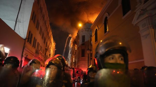 Police in riot gear block a street as a building burns behind them after a day a day of clashes with anti-government protesters in Lima, Peru, Thursday, Jan. 19, 2023. Protesters are seeking immediate elections, Boluarte's resignation, the release of ousted President Pedro Castillo and justice for protesters killed in clashes with police. - Sputnik International