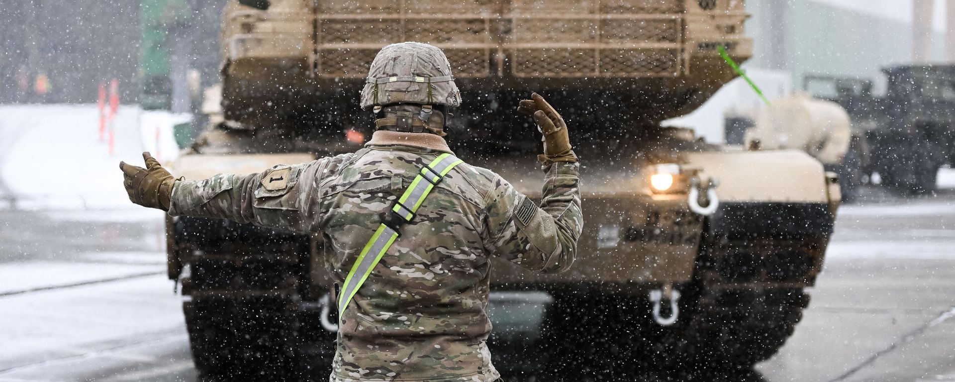 A US Army soldier signals the way to a M1A2 Abrams battle tank that will be used for military exercises by the 2nd Armored Brigade Combat Team, at the Baltic Container Terminal in Gdynia on December 3, 2022 A US Army soldier signals the way to a M1A2 Abrams battle tank that will be used for military exercises by the 2nd Armored Brigade Combat Team, at the Baltic Container Terminal in Gdynia on December 3, 2022 - Sputnik International, 1920, 18.02.2023